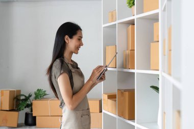 Girişimciler çağdaş bir ofis ortamında ürün envanterini yönetmek için dijital aygıtlar kullanıyorlar.