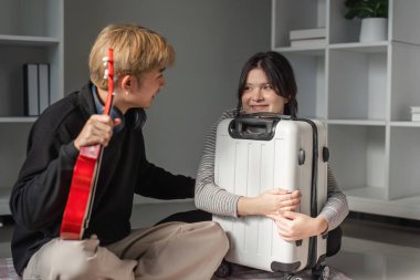 Genç bir çift, heyecan ve macerayı simgeleyen yaklaşan bir gezi için bavullarını sevinçle hazırlıyor..