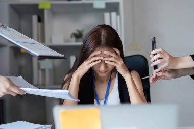 Çağdaş ofis ortamında iş belgeleriyle birden fazla iş yapan profesyonel bir iş kadını..
