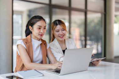 Bir iş kadını, yeni çalışanına parlak, modern ofis ortamında, takım çalışmasını ve profesyonel büyümeyi teşvik etme konusunda rehberlik eder..