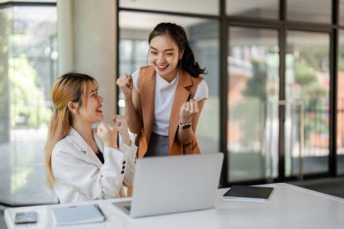 İki başarılı iş adamı modern ofis ortamında iş başarısını kutluyor, neşe ve başarı sergiliyorlar..