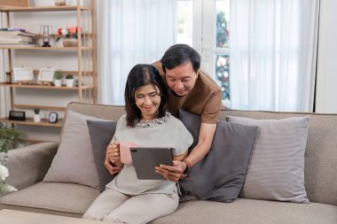 Emekli bir çift rahat oturma odalarında dinleniyor, huzurlu ve rahat bir yaşam tarzının tadını çıkarıyor..