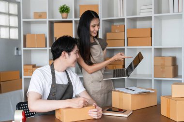 Genç bir çift kutularını toplamak ve internet satış işlerini kendi ofislerinden yönetmek için birlikte çalışıyor..