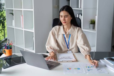 Modern bir ofiste finansal belgeler üzerinde çalışan profesyonel iş kadınları, analiz ve verimliliğe odaklanıyor.