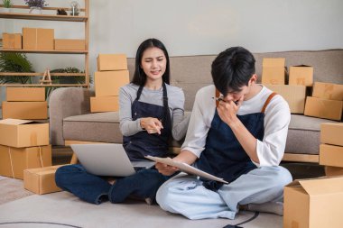 A couple working from home is stressed over a wrong order while managing their online business, surrounded by cardboard boxes. clipart