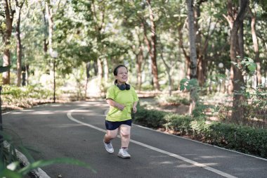 Bir kadın sakin bir bahçede koşuyor, temiz havanın ve doğal çevrenin tadını çıkarıyor..
