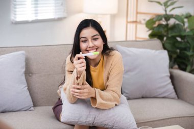 Bir kadın sevinçle hamilelik testinin sonucunu keşfediyor. Rahatlatıcı bir ev ortamında yeni başlangıçları kutluyor..