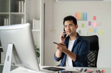 Yaratıcı projeler için dijital araçlar ve renk örnekleri kullanarak modern bir stüdyoda grafik tasarımcısı.