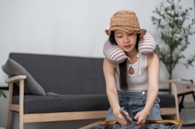 A young woman enthusiastically packs her suitcase, preparing for an exciting travel adventure. Modern style and travel essentials. clipart