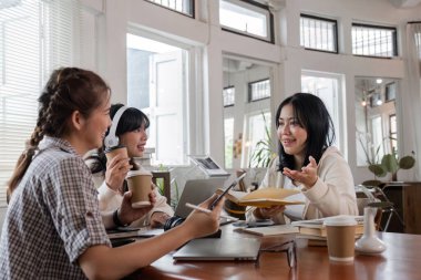 Ödevlerini birlikte yapan öğrenciler, parlak ve modern bir çalışma alanında fikirleri ve kaynakları paylaşıyorlar..