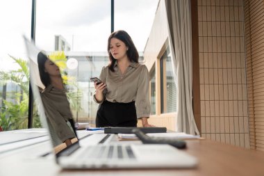 Bir grup iş kadını, strateji geliştirmek ve başarılı olmak için enerjik bir ofiste iş birliği yapıyor..