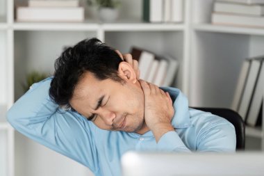 Bir erkek, ofis sendromunun iş sağlığı ve verimliliği üzerindeki etkisini vurgulayan boyun ağrısı yaşar..