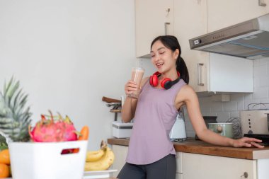 Mutfakta meyve püresi yapan genç bir kadın, sağlık ve sağlığa dikkat çekiyor..