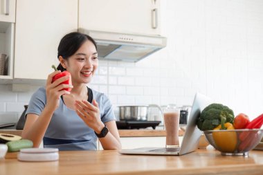 Mutfakta meyve püresi yapan genç bir kadın, sağlık ve sağlığa dikkat çekiyor..