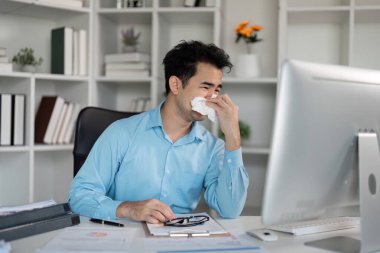 Bir işadamı, grip belirtileri ve ateşle boğuşurken evinden işe konsantre olmaya çalışır..