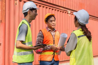 Genç bir lojistik mühendisi, deneyimli bir yönetici ve bir inşaat sahasında proje tartışması yapan bir teknisyen, elinde planlar ve aletler var..