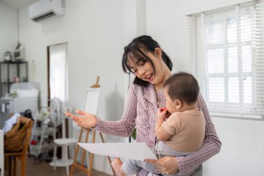 A cheerful single mother balances work conversations and childcare, confidently managing her responsibilities as she clutches documents and cradles her infant. clipart