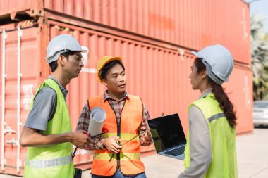 Aralarında bir kadın danışman ve iki erkek işçinin de yer aldığı üç inşaat işçisi, dizüstü bilgisayar kullanarak proje özellikleri üzerinde işbirliği yapıyorlar.