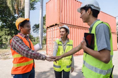 Bir lojistik mühendisliği ekibi, canlı bir inşaat alanında takım çalışması ve işbirliği sergileyerek, anlaşmaları imzalamak için el sıkışma gerçekleştirdi..