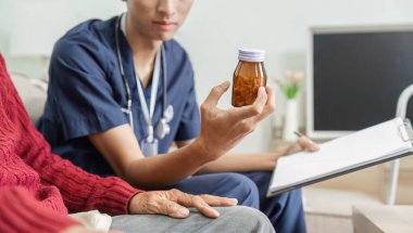 Hemşire, reçeteleri ev sağlığı ortamında anlamanın önemini vurgulayarak, yaşlı bir hastaya ilaç detaylarını açıklar..