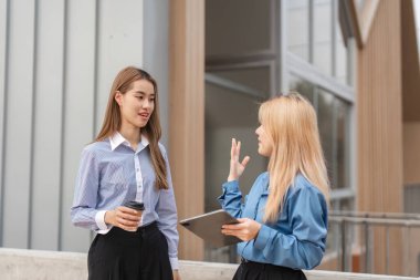 Birinde bir kahve fincanı, diğerinde açık hava ortamında işbirliğini vurgulayan bir tablet kullanırken, iki farklı kadın animasyon tartışmasına girdi..