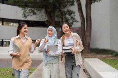 Bir grup farklı üniversite öğrencisi kampüste eğlenirken birlikte yürüyüp neşeli sohbetler ediyorlar..
