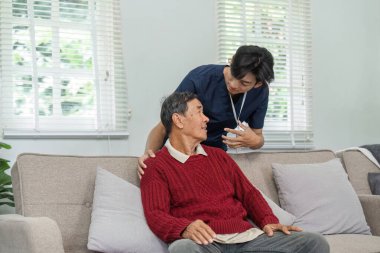 Hemşire, konforlu bir evde yaşlı bir hastaya şefkatli destek sunarak sağlık hizmetlerinde güven ve iletişimi teşvik eder..