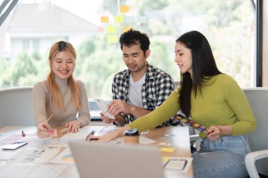 Parlak bir ofis çalışma alanında fikirleri paylaşırken yaratıcı kavramlar ve planlama konusunda işbirliği yapan çeşitli profesyoneller..