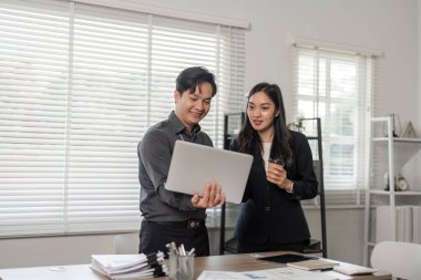 İki profesyonel proje ilerlemesi, takım çalışması ve parlak bir ofis ortamında işbirliği konularını görüştü.