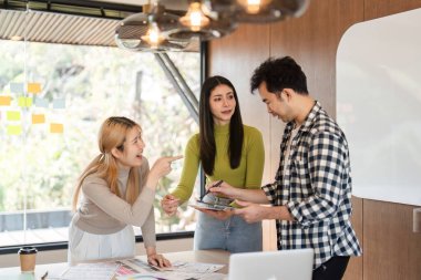 Çağdaş ofis ortamında çeşitli bir ekip fikirleri paylaşıyor ve tasarım kavramlarını tartışıyor..