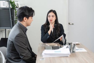 Çağdaş bir ofis ortamında proje ayrıntılarını ve stratejilerini analiz eden iki iş adamı arasında ciddi bir tartışma.