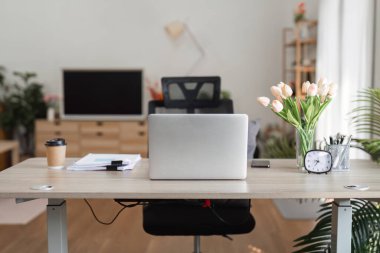 Bilgisayarı, ofis malzemelerini ve uzaktan kumandayı temsil eden bir kahve fincanını içeren boş bir çalışma alanı..