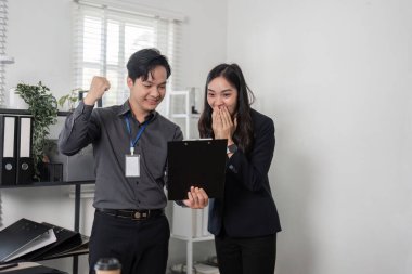 İki meslektaş, parlak bir ofiste proje sonuçlarıyla ilgili bir tartışmaya girerek, takım çalışması ve profesyonel müdahalenin altını çizdi.