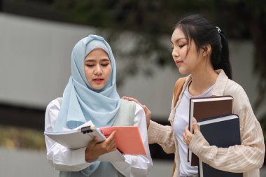 İki farklı üniversite öğrencisi, biri tesettür takıyor, kampüste birbirlerini desteklerken ciddi bir tartışma içindeler..