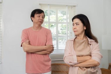 Orta yaşlı bir çift kollarını kavuşturmuş içeride endişe ve tatminsizlik ifadeleri sergiliyorlar. İlişkilerindeki gerginliği simgeliyorlar..