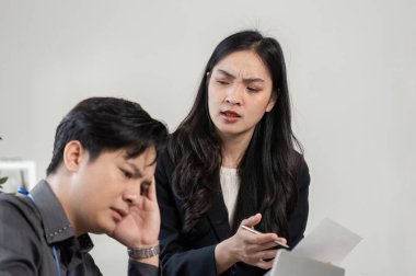 Endişeli bir kadın profesyonel, sıkıntılı bir erkek meslektaşıyla proje konularını ele alarak, takım çalışmasında iletişimin önemini vurguladı.