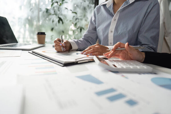 Two financial workers engage in a lively discussion about tax strategies and accounting data in a modern office setting.