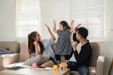 Neşeli bir aile bir zafer anını paylaşır, kızlarıyla para ve mali sorumluluk biriktirmeyi öğrenirler..