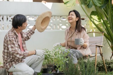 Çeşitli çiftler neşe içinde bahçe işleriyle uğraşırken, biri hasır şapkayı tutarken diğeri de kahve bardağını tutarken kahkahalarını paylaşıyorlar, bahçede vakit geçiriyorlar..