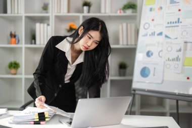 Mali doğruluğa olan bağlılığını vurgulayan bir muhasebeci, vergi belgelerini dikkatle inceliyor..