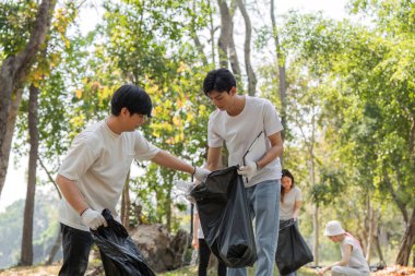 Adanmış gönüllüler, daha temiz ve sürdürülebilir bir çevreyi desteklemek için atık toplayan bir toplum temizliğine giriştiler..