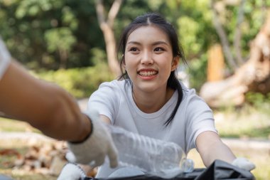 Neşeli genç bir kadın toplum temizliği, takım çalışması ve sürdürülebilirliğe olan bağlılığını sergiliyor..