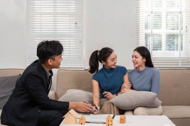 Bir emlakçıyla iki kadının ev seçeneklerini tartıştığı, toplum bilincini geliştirdiği ve işbirliği yaptığı canlı bir danışma sahnesi..