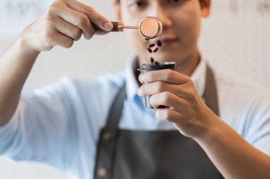 Titiz bir dikkatle bir barista kahve çekirdeklerini demleme sürecinin bir parçası olarak tartar.