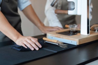 Kendini işine adamış bir barmen tezgahı temizleyerek çalışma alanını hazırlar ve fevkalade bir kahve deneyimi için el değmemiş bir ortam sağlar. Detaylara dikkat etmek kahve işinde anahtardır..