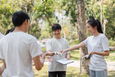 Gönüllüler temizlik çabalarına eldiven ve araç gereçler alarak hazırlanıyorlar. Çevre yönetimine bağlılıklarını gösteriyorlar..