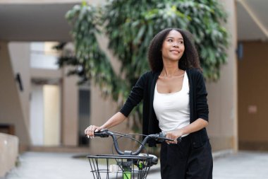 Bisiklete binen kadın, keyif veriyor ve bisiklet sürerek, yaşam tarzında sürdürülebilirlik göstererek sağlıklı bir yaşamı teşvik ediyor..