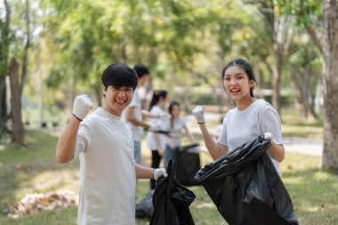 İki genç gönüllü çabalarını bir yumrukla kutluyorlar. Toplumu temizleme girişimleri için coşku gösteriyorlar..