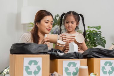 İkili, kupa ve kap gibi geri dönüşümlü materyalleri incelerken, sürdürülebilirliği tartışırken eğlenceli bir anda yakalıyor..