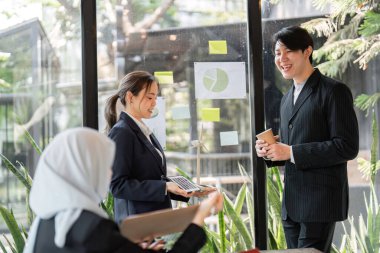 Parlak bir ofiste, çeşitli bir ekip sürdürülebilir projeler üzerinde işbirliği yaparak, güçlü profesyonel ilişkiler kurarken çevresel sorunlara yaratıcı çözümler üretiyor..